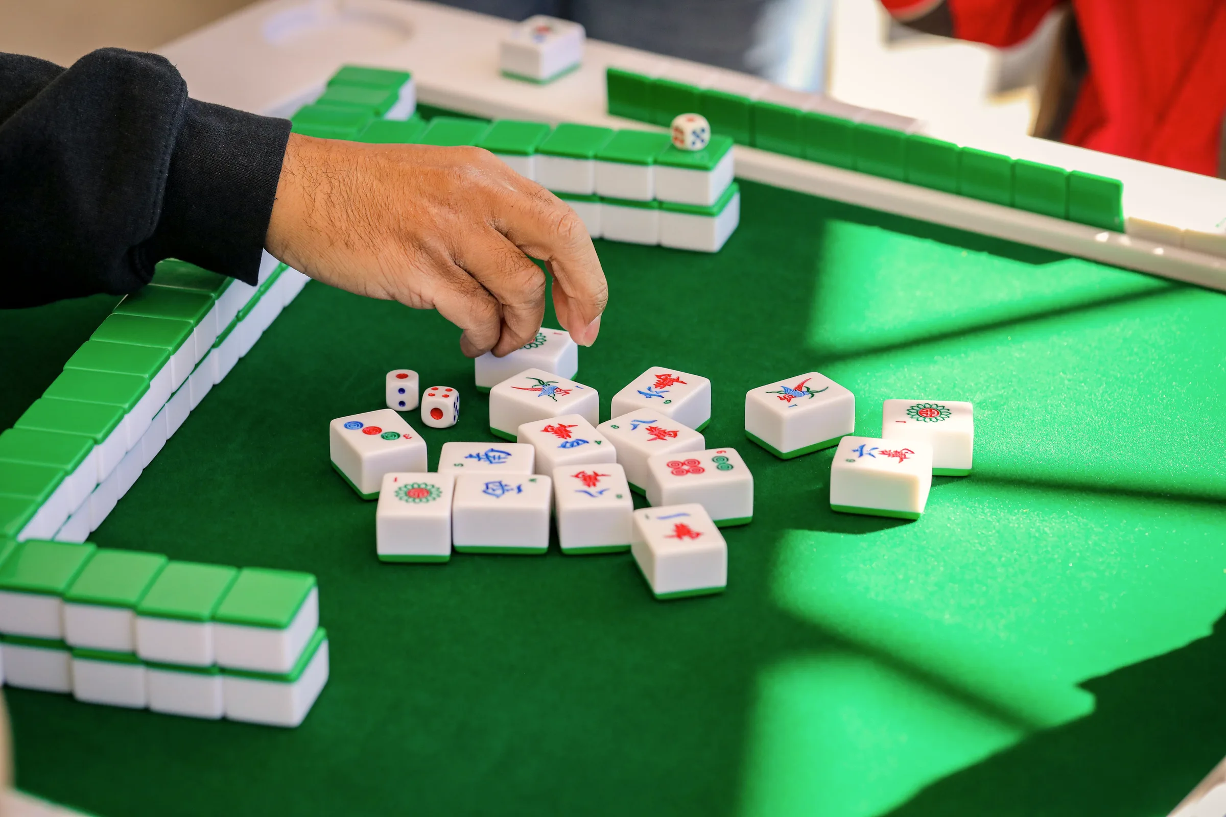 Mah-jong tiles arranged in rows on a green table