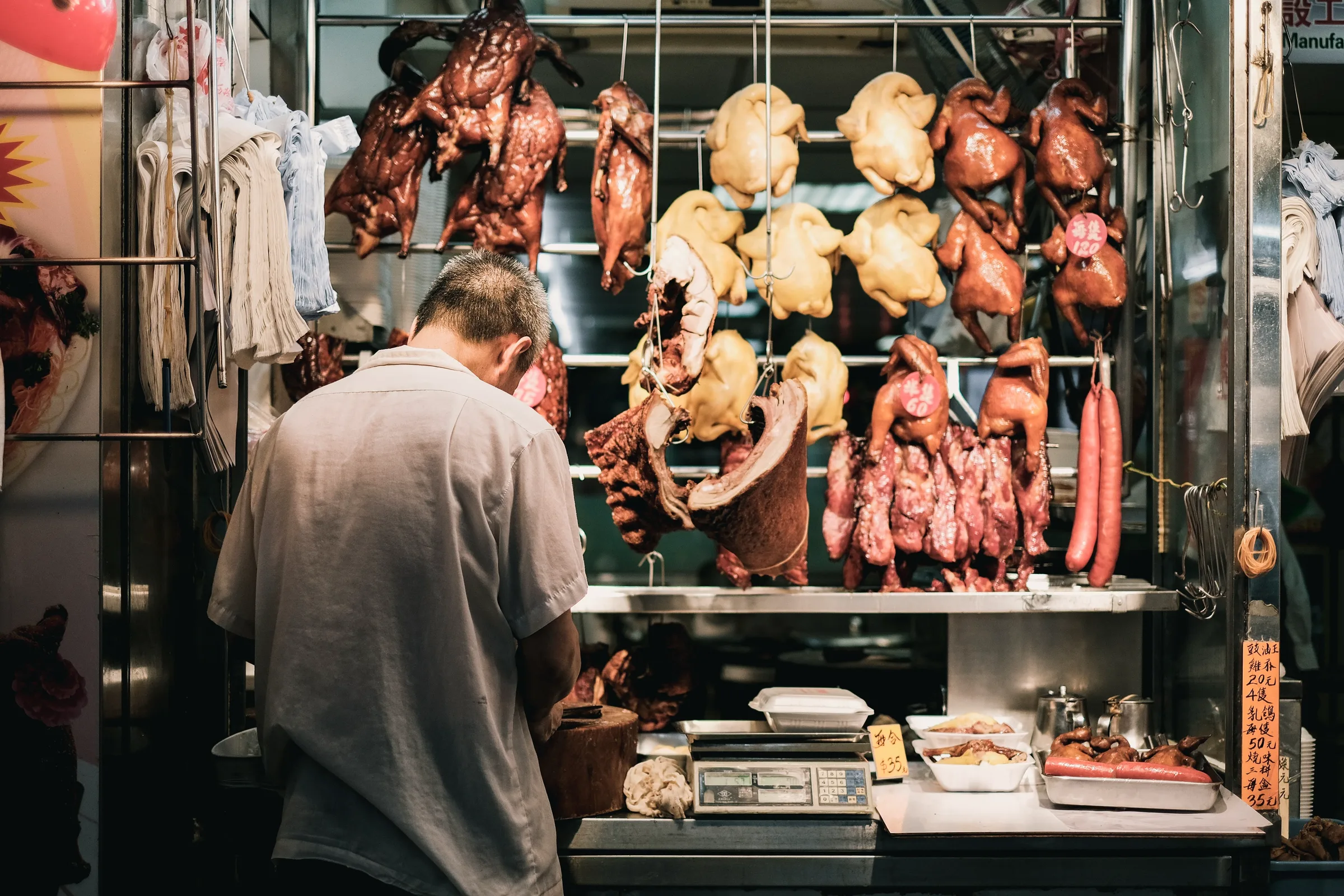 A cleaver resting beside sliced roast pork