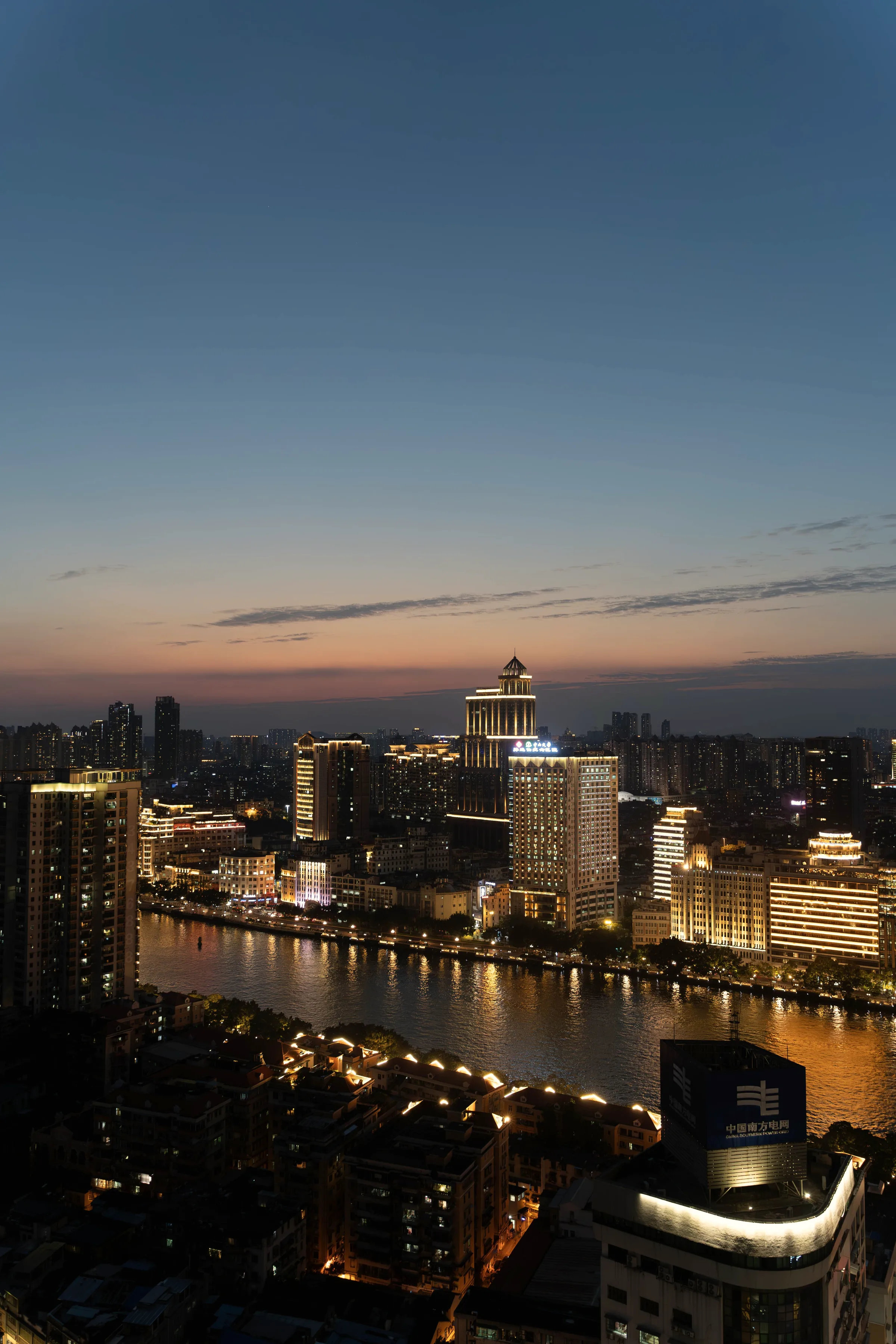 River city at dusk with lit buildings along the water