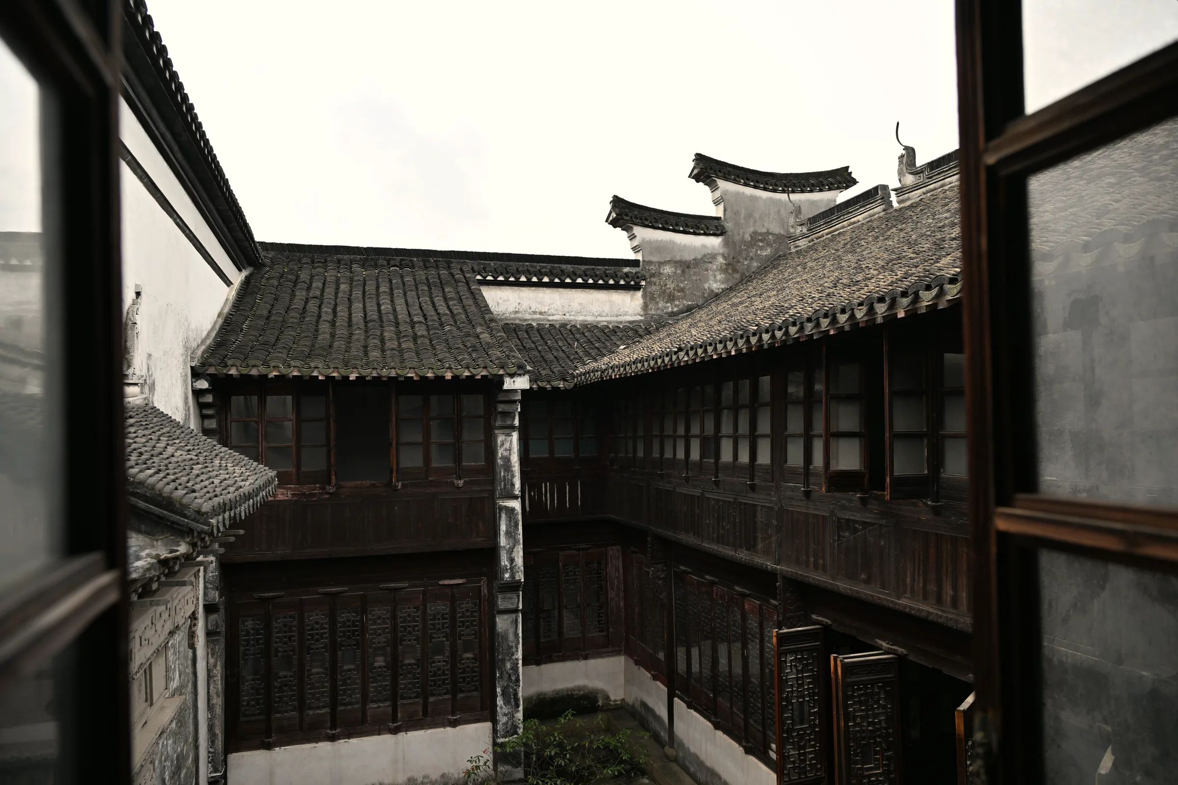 Grey tiled roofs and timber galleries around an open courtyard