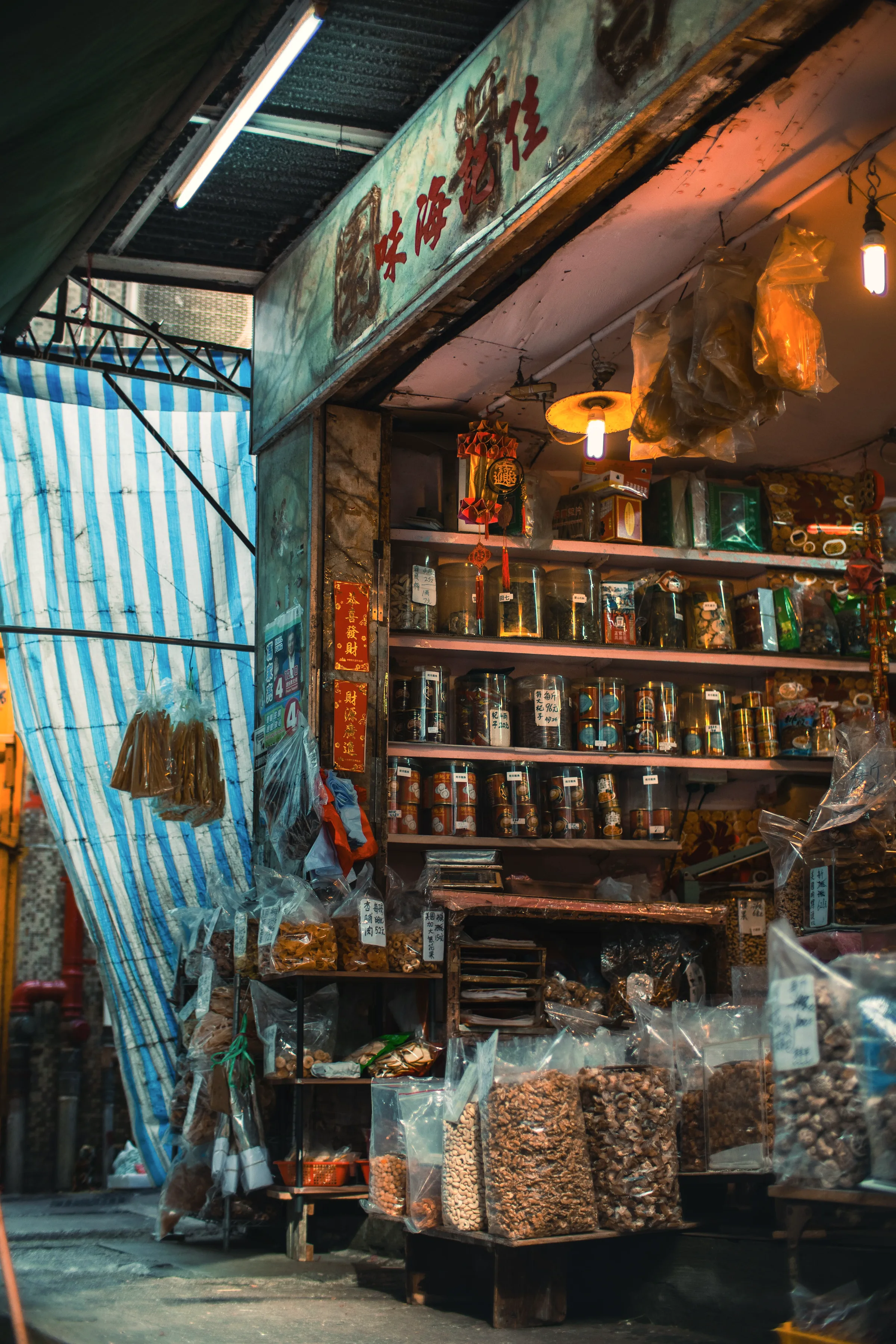 A lit street food stall with steam and skewers